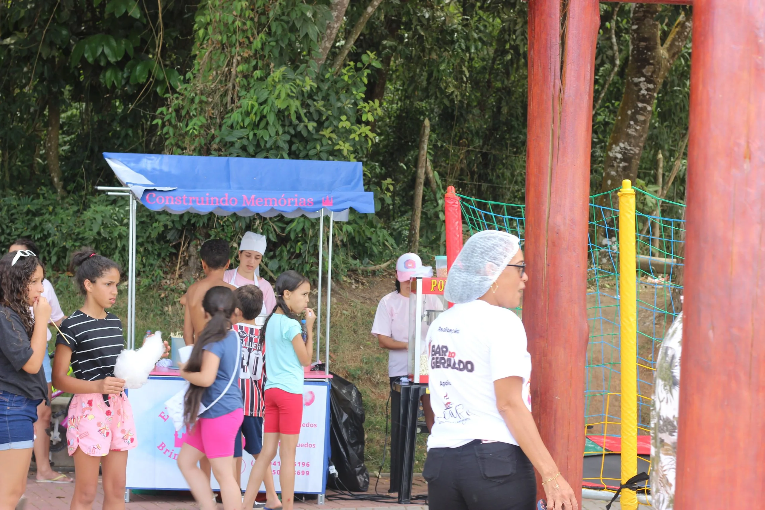 As crianças pegam algodão doce distribuído gratuítamente